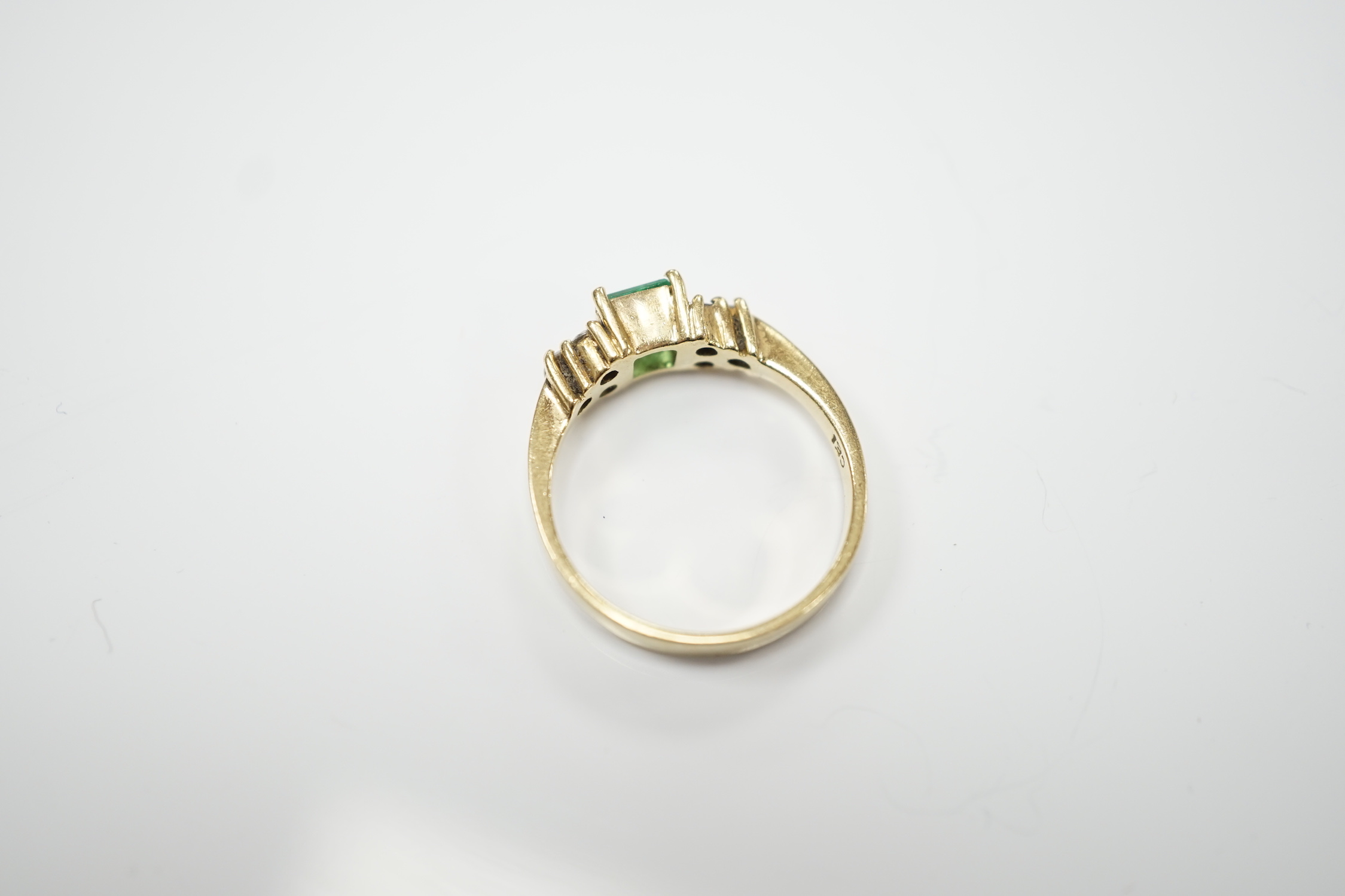 A modern 18k, emerald and diamond set cluster ring, size N, gross weight 3.8 grams.